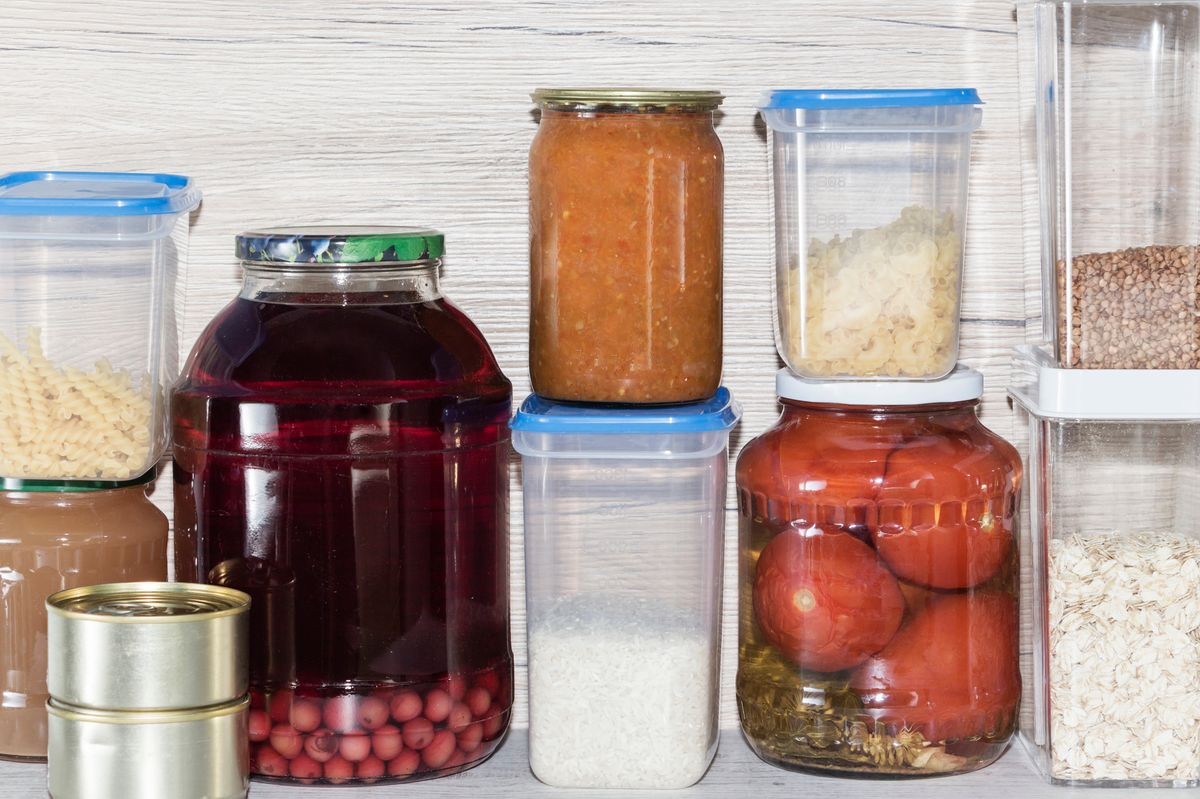 Storage shelves in pantry with homemade canned preserved fruits and vegetables